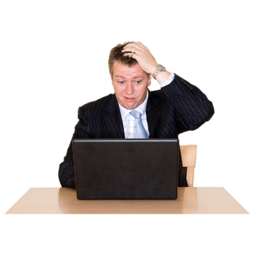A man wearing a suit sitting at a laptop computer scratching his head and looking confused