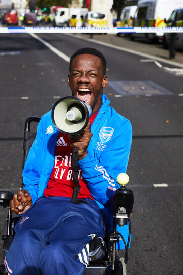 Brendan in a wheelchair shouting through a loudspeaker