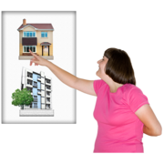 A woman pointing to a picture of a house rather than a picture of an block of flats or offices