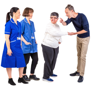 A man points the way for a woman next to some healthcare professionals