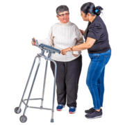 A lady gets support to walk from her friend, using a walking frame. 