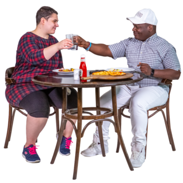 Two men sit at a table eating a meal together