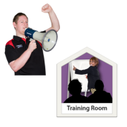A man speaking into a megaphone, next to a woman in a training room