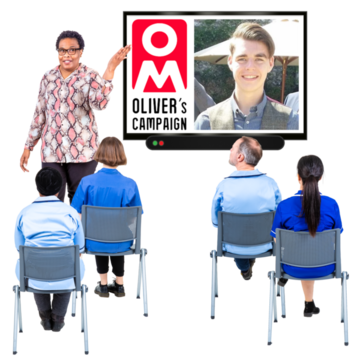 Four students in a classroom are facing a teacher who is using a large computer screen showing a picture of the Oliver McGowan campaign