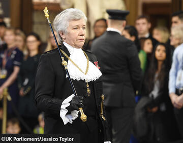 Black Rod is dressed in black and carrying a large stick