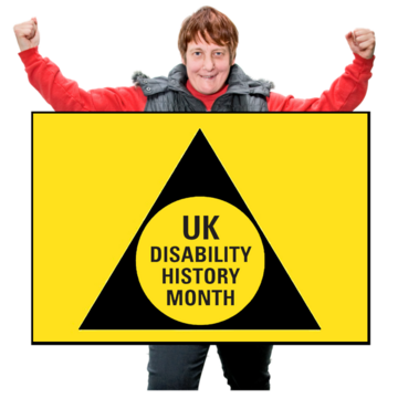 A woman standing with a yellow sign that has the UK Disability History Month logo