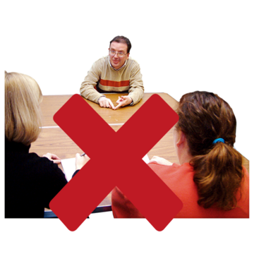 A photograph of a man having an interview. The photograph has a red cross over it.