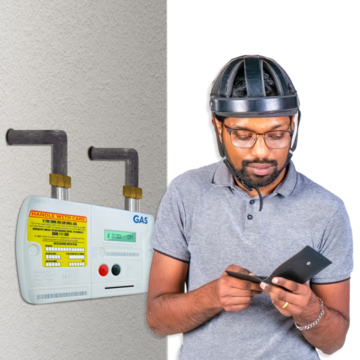 A man looking into his wallet standing next to a pre payment gas meter