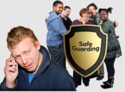A worried man making a telephone call in front of a group of people who are standing behind a Safe Guarding shield