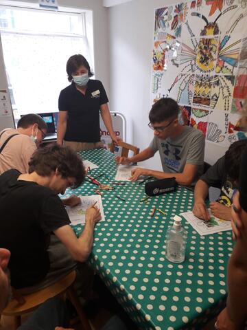 A group of people sat around a table, drawing
