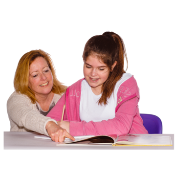 A woman is helping a young girl with her school work