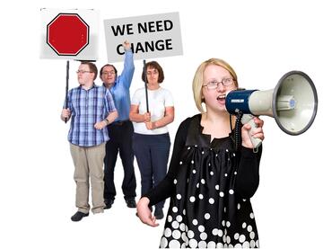 A group of people holding up signs for change and another person is shouting through a megaphone