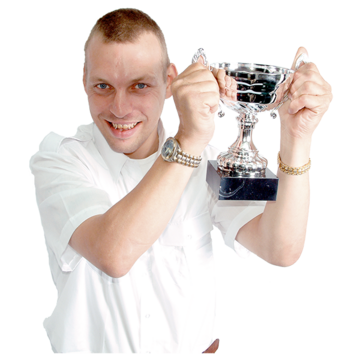 A man in a white shirt smiling and holding a trophy