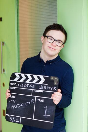 George holding a clapperboard
