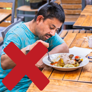 A man eating food with a red cross over the image