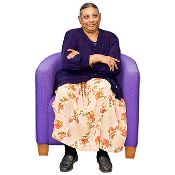 A lady sitting in a chair with her arms folded.