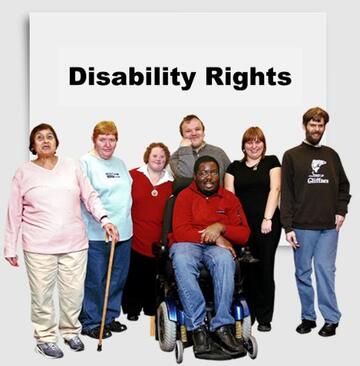 a group of people with disabilities standing in front of a sign which says Disability Rights