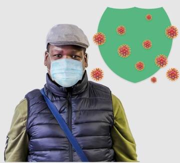 A man wearing a face covering next to a green shield graphic which is protecting from a virus