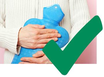 Someone holding a hot water bottle against their jumper and a green tick.