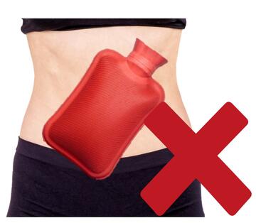 A hot water bottle on a person's stomach with a red cross beside it.