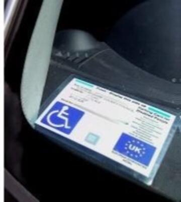 A Blue /badge on a car dashboard.