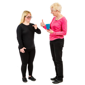 A girl pointing to herself and a lady holding a cup with her thumb up.