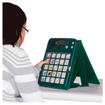 A woman using a communication aid that sits on a desk