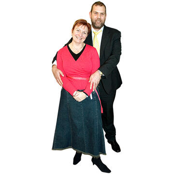 A man standing with his arms around a woman.
