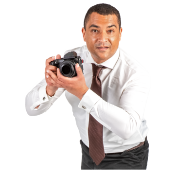 A man in a white shirt and brown tie holding a camera
