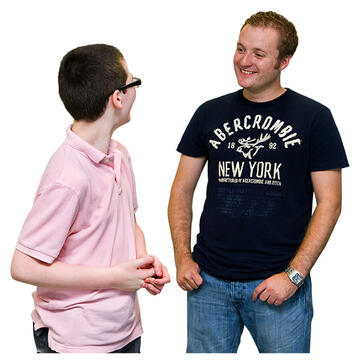 A man smiling and looking at a younger man.