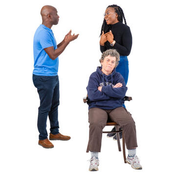 2 people standing behind someone and talking and leaving them out of the conversation.