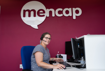 Helpline adviser on the phone whilst using a computer