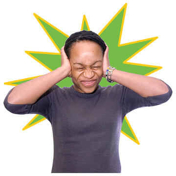A lady with hands over her ears and her eyes shut.