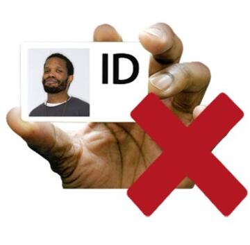 A hand holding photo ID card with a red cross next to it