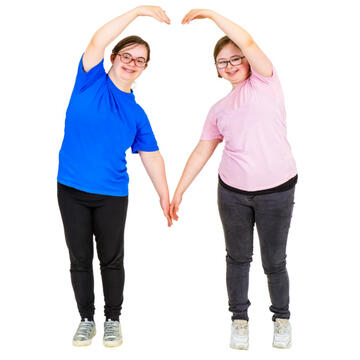 2 girls holding hands and making a heart shape with their other hands.