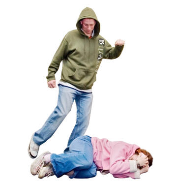 Someone wearing a hoody kicking someone lying on the ground.