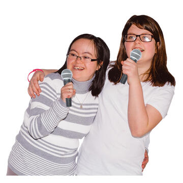 2 girls holding microphones and looking happy.