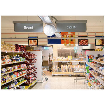 An aisle in a supermarket with bread either side.