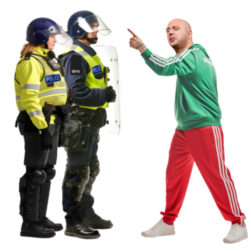 A man angrily pointing at two police officers wearing riot protection clothing