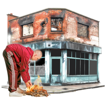 A man starting a fire in front of a damaged building