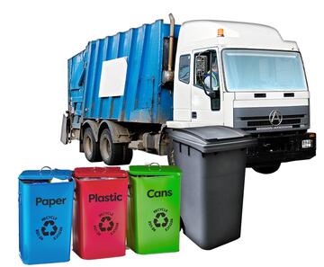 A lorry behind a row of recycling boxes and a bin.