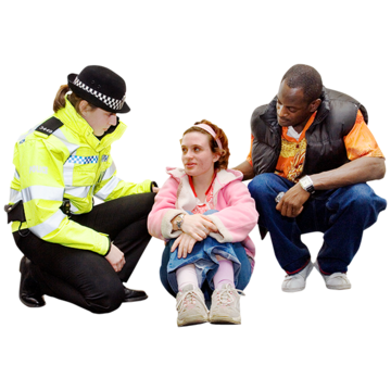 A man and a police woman are comforting a young girl who is crouched on the floor
