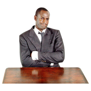 A man sitting at a table with his arms folded.