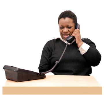 A woman sitting at a desk holding a phone to her ear