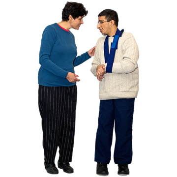 A man and a woman standing next to each other talking. The woman has her hand on the man's arm