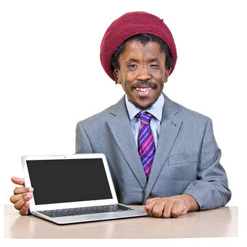 A man sitting at a table beside a laptop.