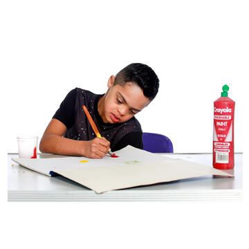 A boy sitting at a table painting.