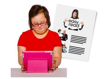 A girl looking at an ipad with some easy read information behind her.