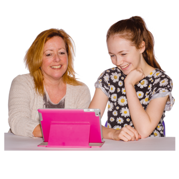 A woman and a younger woman sit next to each other looking at a tablet computer in a pink case