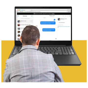 A man looking at a laptop with a messenger program open on the screen